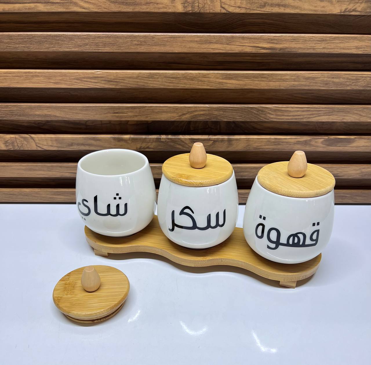 Ensemble de pots en céramique blanche avec couvercles et plateau en bois pour le café, le sucre et le thé